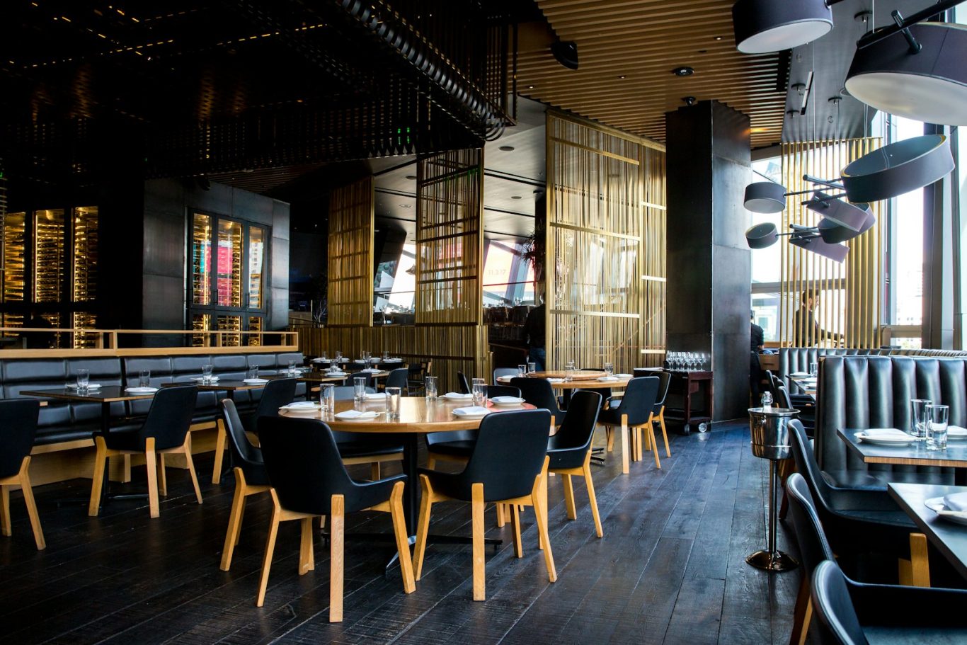 Wandleranlage Eleganter Innenraum eines Restaurants mit gedeckten Tischen und modernen Stühlen.