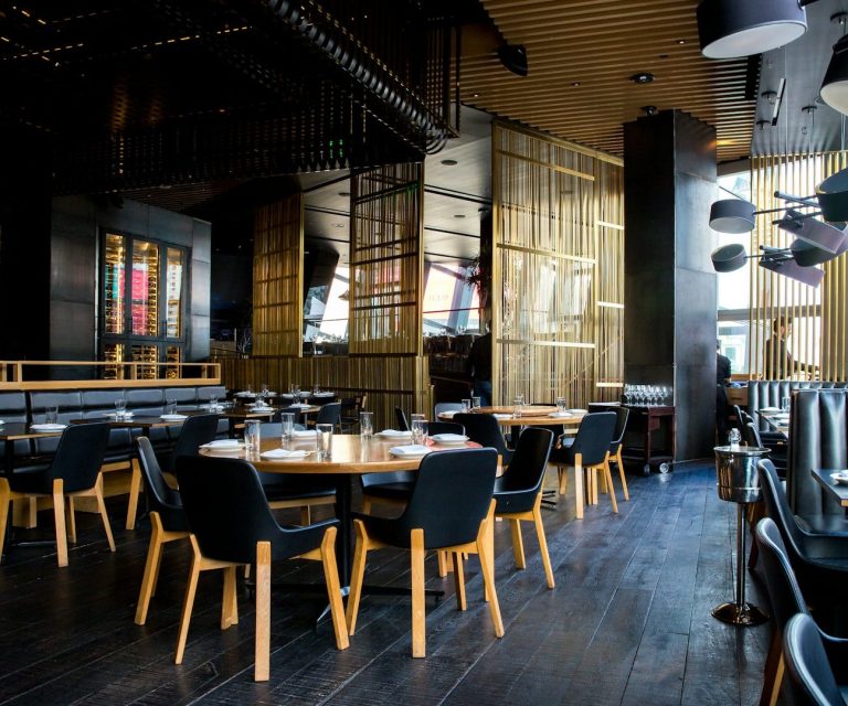 Modernes Restaurant mit Holzstühlen und stilvollem Ambiente, gedeckten Tischen.