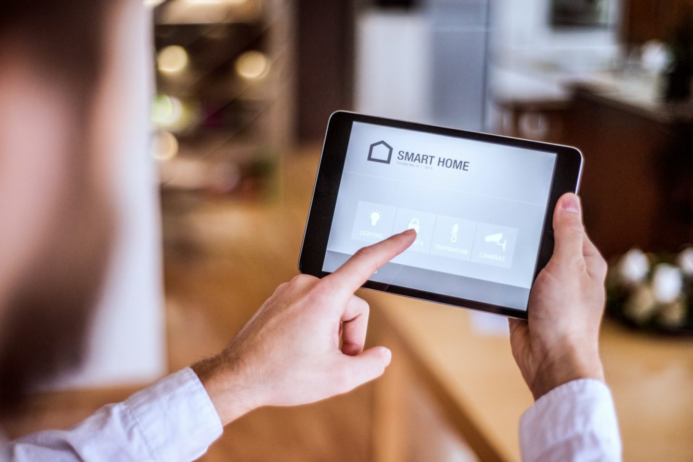 Smart Home Person bedient ein Tablet mit einer Smart-Home-Steuerung in einem modernen Raum.