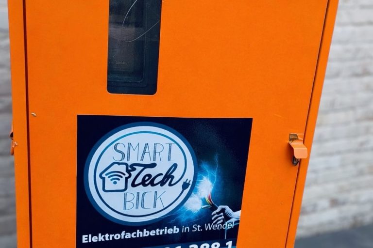 Oranger Baustromverteiler-Kasten mit einem Hinweis auf Elektrofachbetrieb "SmartTech Bick".