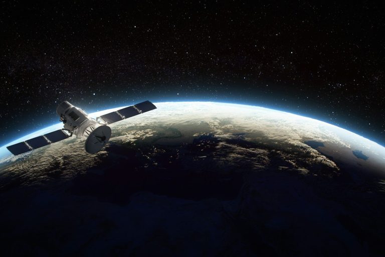 Raumsonde über der Erde, mit Sicht auf den Planeten und den Weltraum im Hintergrund.